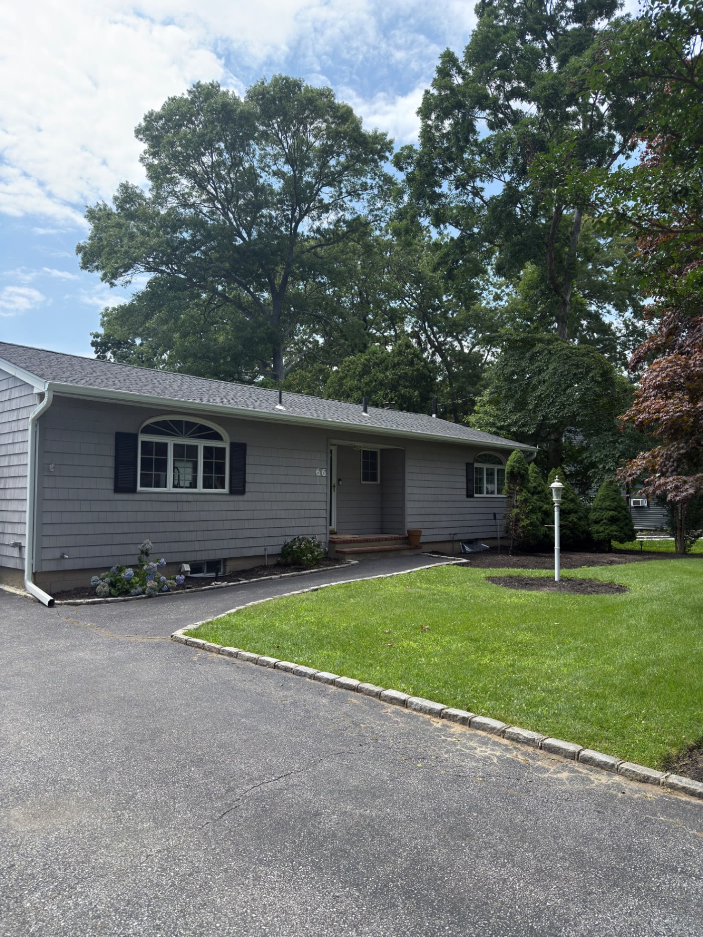 Manicured Long Island front yard with sculpted shrubs and fresh mulch